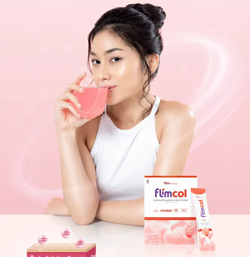 Perempuan meminum Flimcol dari gelas, di samping box dan sachet Flimcol rasa Stroberi