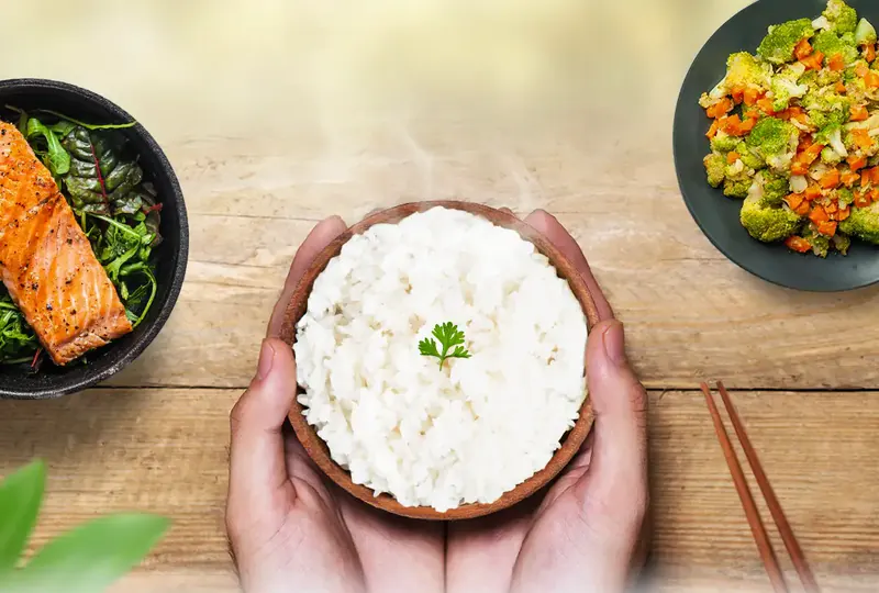 Semangkuk Flimrice di tangan, dengan lauk salmon dan sayur